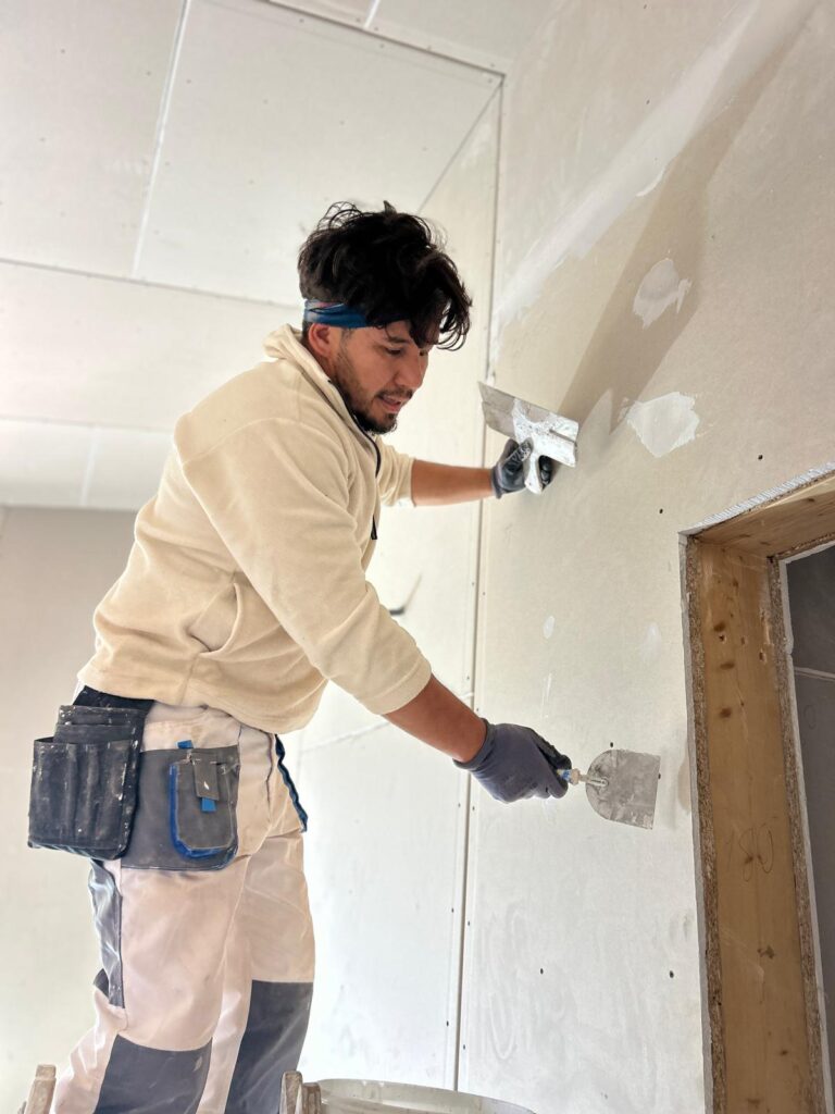 Ali Alizadah, Inhaber von Maler Gedik, beim Verspachteln einer Wand